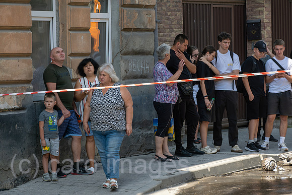 Ukraine, Lwiw - Ukraine-Krieg: Betroffen schauende Passanten und Anwohner nach russischen Raketen- und Drohnenangriff auf Wohnviertel im Zentrum (7 Tote, ca. 30 Verletzte)