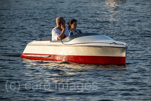 Deutschland, Hamburg - Telefonierender Mann mit Begleiterin in einem Motorboot auf der Aussenalster