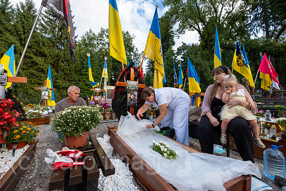 Ukraine, Lviv - Widow with her parents and daughter mourning at the grave of her husband on the Field of Mars, a cemetery of honour for Lviv soldiers who died in the war in eastern Ukraine