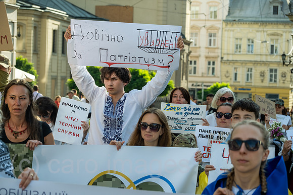Ukraine, Lwiw - Soldatenfrauen und ihre Kinder demonstrieren fuer die Heimkehr ihrer Maenner und Vaeter von der Front, Transparent: LEBENSLANG GEFANGEN FUER PATRIOTISMUS?