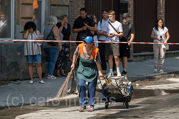 Ukraine, Lwiw - Ukraine-Krieg: Betroffen schauende Passanten und Anwohner nach russischen Raketen- und Drohnenangriff auf Wohnviertel im Zentrum (7 Tote, ca. 30 Verletzte)