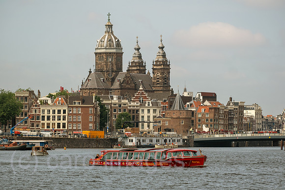 Niederlande, Amsterdam - Blick ueber den frueheren Meeresarm IJ auf die Basilika St. Nikolaus, vorne ein Ausflugsboot
