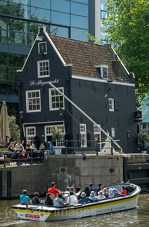 Niederlande, Amsterdam - Ausflugsboot im Grachtenguertel vor De Sluyswacht, Gastronomie in einem historischen und schief stehendem Haus