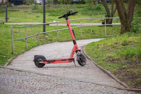 Berlin, Deutschland - Abgestellter E-Scooter auf einem Fussweg