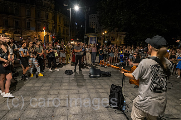 Ukraine, Lviv - young people listen to street music on Prospekt Svobody, the city's main boulevard