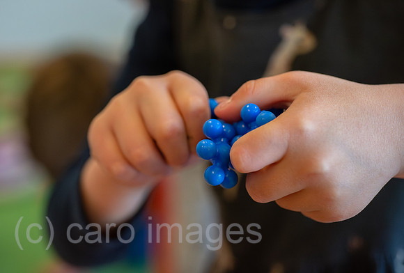 Berlin, Deutschland - Kinderhaende mit blauen Sensorikkugeln