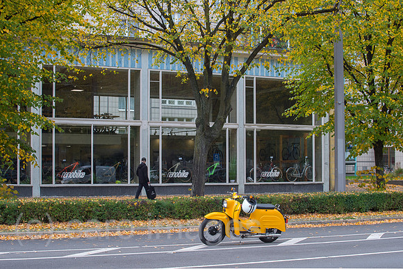 Berlin, Deutschland - Pavillion in der Karl-Marx-Allee mit parkender gelber Schwalbe