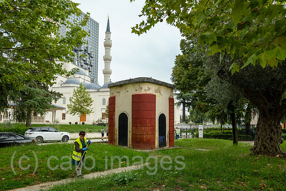 Albanien, Tirana - Staedtische Angestellte beim Laubharken in einem Park im Zentrum, hinten die Namazgah-Moschee und Hochhaus