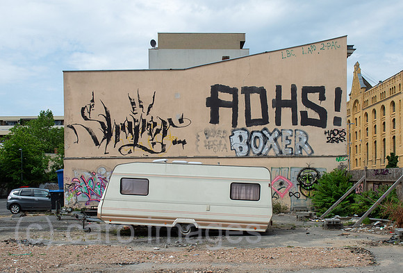 Berlin, Deutschland - Bespruehte Hauswand mit Wohnwagen