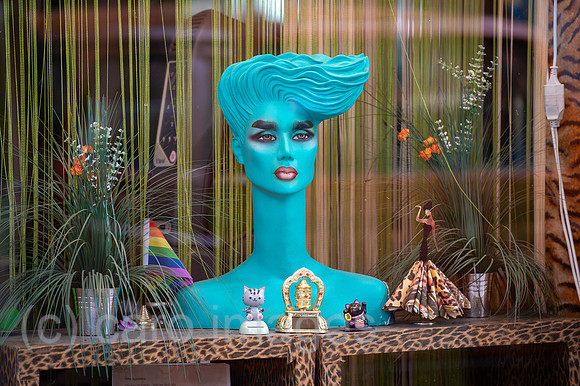 Berlin, Deutschland - Schaufenster eines Friseursalons mit diversen Utensilien und Regenbogenflagge