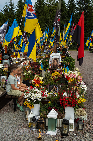 Ukraine, Lwiw - Kinder an dem Grab einer Soldatin auf dem Marsfeld Ehrenfriedhof der gefallenen Lwiwer Soldaten im Ukrainekrieg