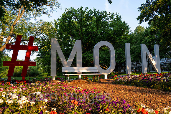 Germany, Bremen - moin greeting as meter-high lettering in the city, behind it the ramparts. Moin is a North German greeting in Low German and means something like ëhave a nice dayí.